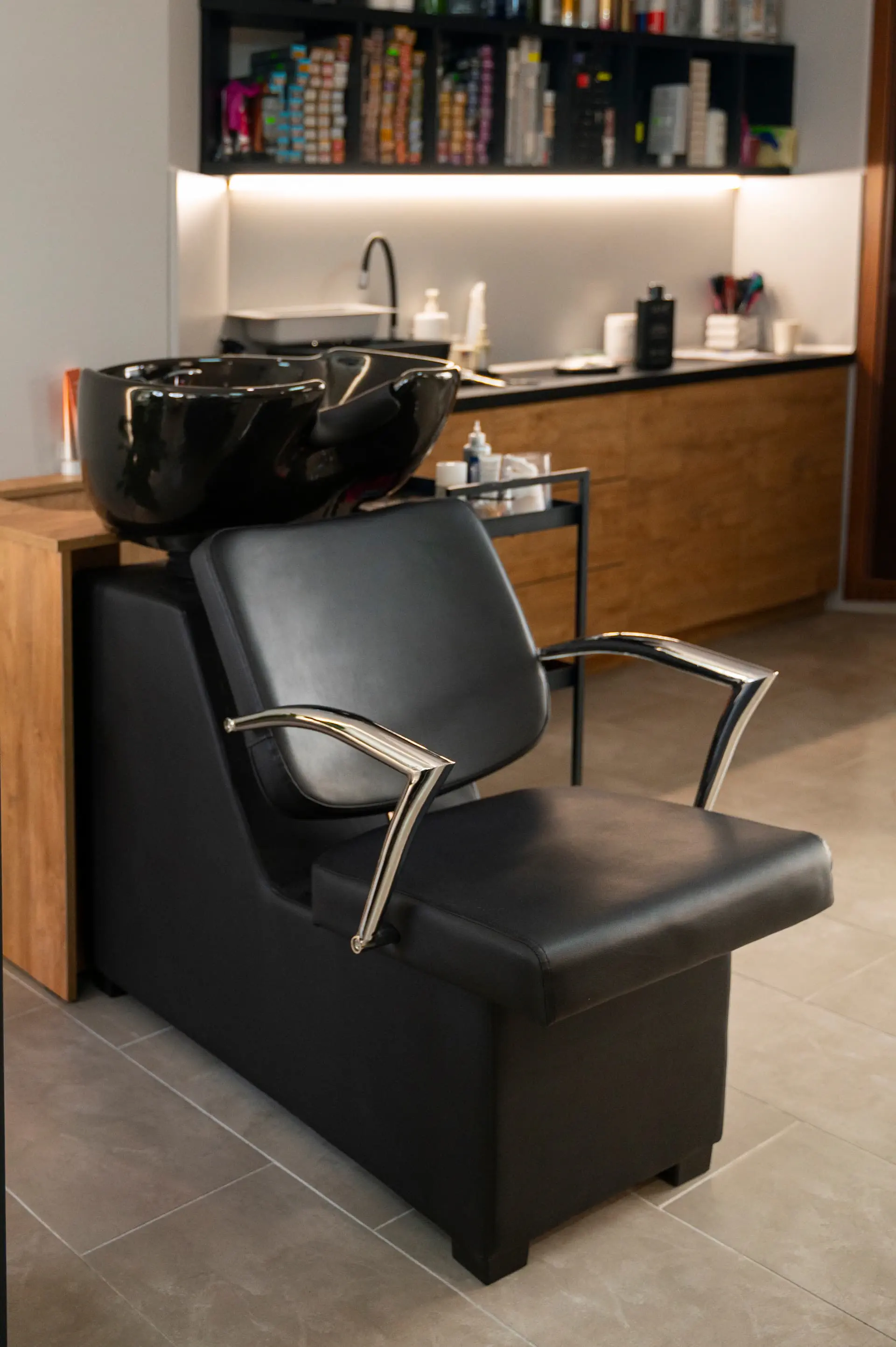 Profesjonalna myjnia fryzjerska z czarnym fotelem w salonie fryzjerskim